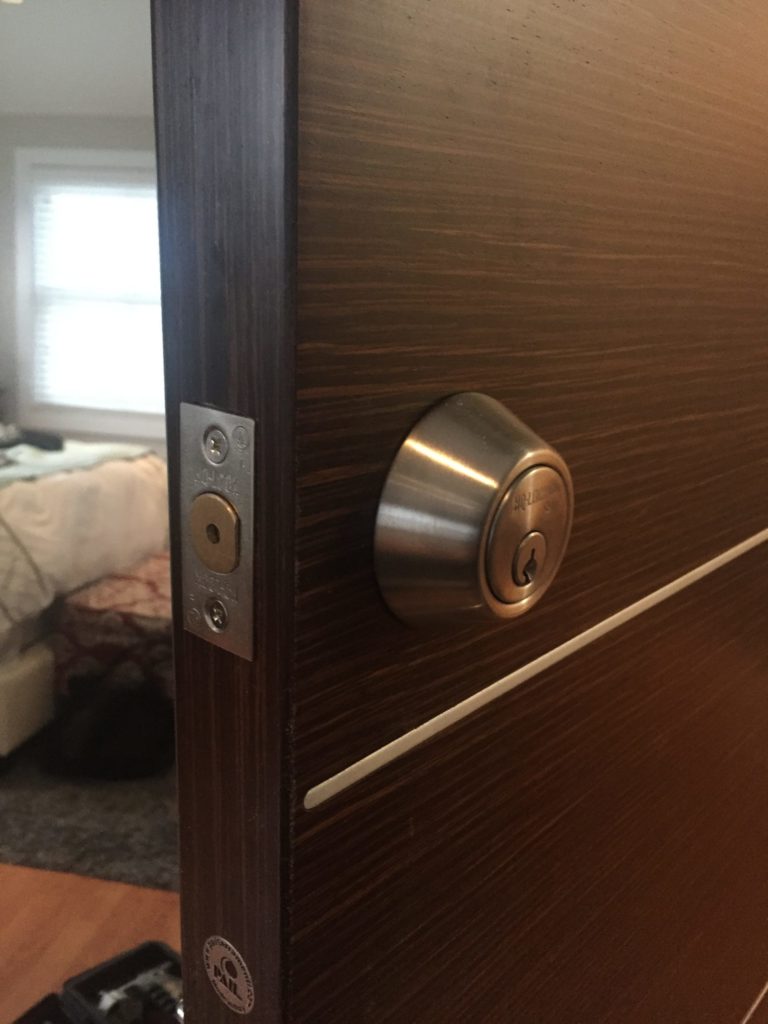 Deadbolt installed on a dark wood door